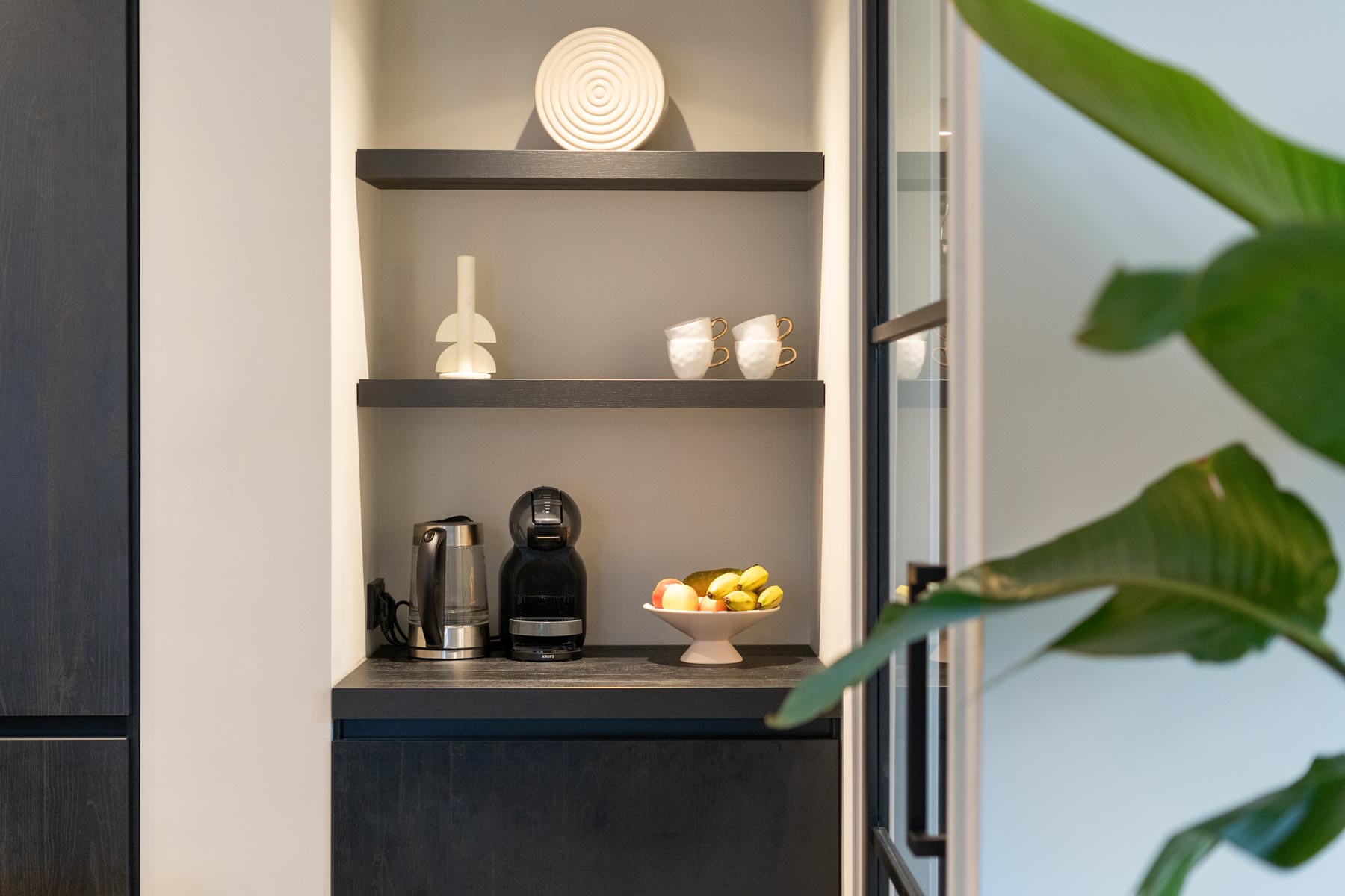 Koffiecorner in zwarte keuken met wandplankjes